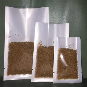 May include: Three white stand-up pouches with brown sugar inside. The pouches are different sizes, with the largest pouch on the left and the smallest pouch on the right.