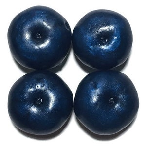 May include: Four dark blue, round, faux blueberries. The blueberries have a shiny, metallic finish.