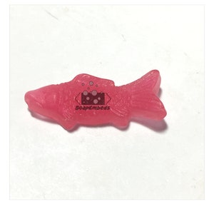 May include: A pink fish-shaped gummy candy.