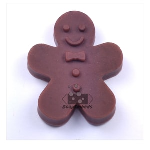 May include: Brown gingerbread man soap mold with a smiling face, bow tie, and button details.