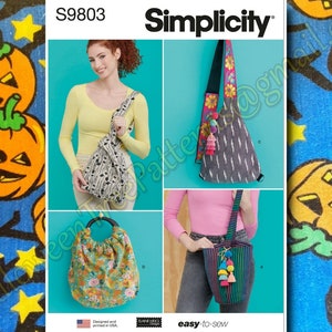May include: Simplicity S9803 sewing pattern featuring four different bag designs. The bags include a tote with a wooden handle, a striped bag with pom-pom accents, a patterned shoulder bag, and a black and white print bag. The pattern is easy-to-sew.
