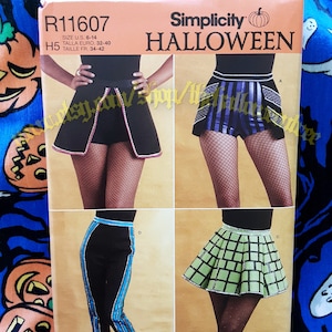 May include: Simplicity Halloween sewing pattern R11607 for sizes UK 6-14, Euro 32-40, and French 34-42. The pattern includes four different costume designs: a black skirt with a red and white trim, a striped skirt with a black and white trim, a black skirt with a blue and white trim, and a green skirt with a white trim.