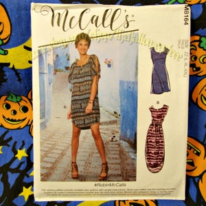 May include: McCall's sewing pattern featuring a woman in a patterned dress with cut-out sleeves. The pattern includes multiple view options and simple instructions. The size is ZZ (L-XL-XXL). The hashtag #RobinMcCalls is visible.