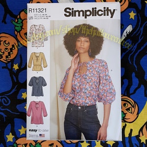 May include: Simplicity sewing pattern R11321 for a blouse with a keyhole neckline and gathered sleeves. The envelope displays four variations of the top in floral, solid, and patterned fabrics, with sizing information for U.S. sizes 16-24.