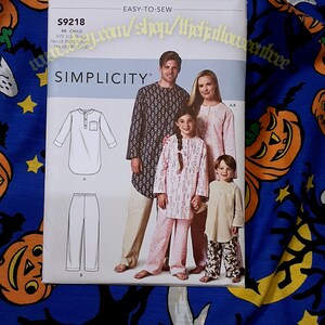 May include: Simplicity sewing pattern S9218 for children's pajamas. The pattern cover features a family wearing the pajamas. The pattern includes sizes from XS to XL. The text "EASY-TO-SEW" is visible.