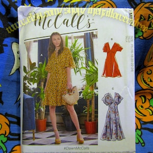 May include: A McCall's sewing pattern package showing a woman in a yellow patterned dress. The package includes illustrations of three dress styles. The text on the package includes "McCall's" and "#DawnMcCalls".