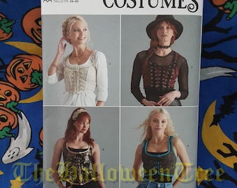 May include: A Simplicity sewing pattern for costumes, featuring four different designs. The pattern number is S9592, and the sizes are US 6-12, Euro 32-38, and French 34-40. The designs include a white peasant top, a black corset top, a blue and white striped top, and a red and black corset top.