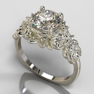 May include: A silver ring with a large, round, clear diamond center stone. The band is decorated with intricate floral designs and smaller diamonds.