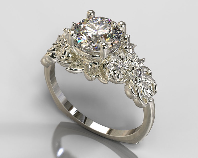 May include: A silver ring with a large, round, clear diamond center stone. The band is decorated with intricate floral designs and smaller diamonds.