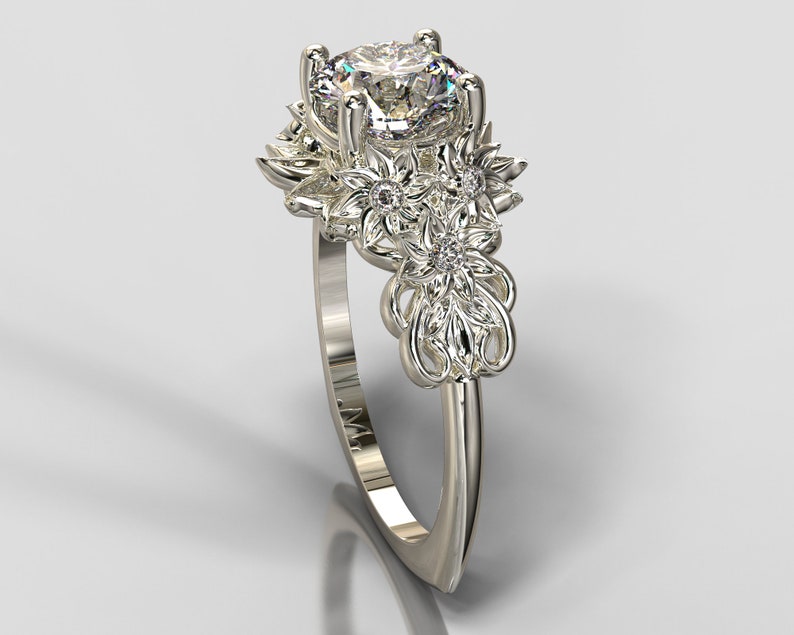 May include: A silver ring with a large, clear, round gemstone surrounded by smaller gemstones and intricate floral designs.