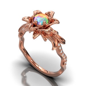 Puede incluir: Anillo de oro rosa con dise&ntilde;o floral y &oacute;palo en el centro. El anillo tiene un engaste floral y una banda adornada con peque&ntilde;os diamantes brillantes. El &oacute;palo muestra una gama de colores.
