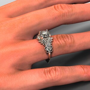May include: A silver engagement ring with a large round center stone and smaller stones set in a floral design.