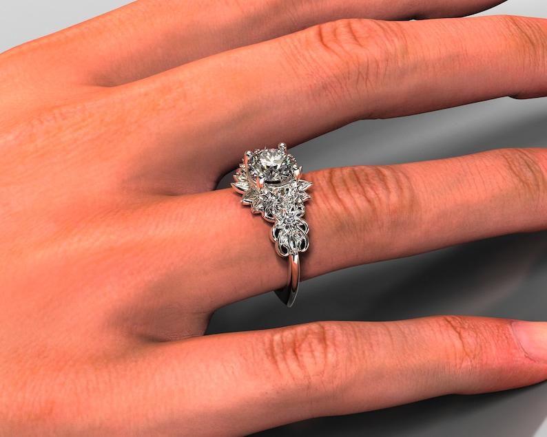 May include: A silver engagement ring with a large round center stone and smaller stones set in a floral design.