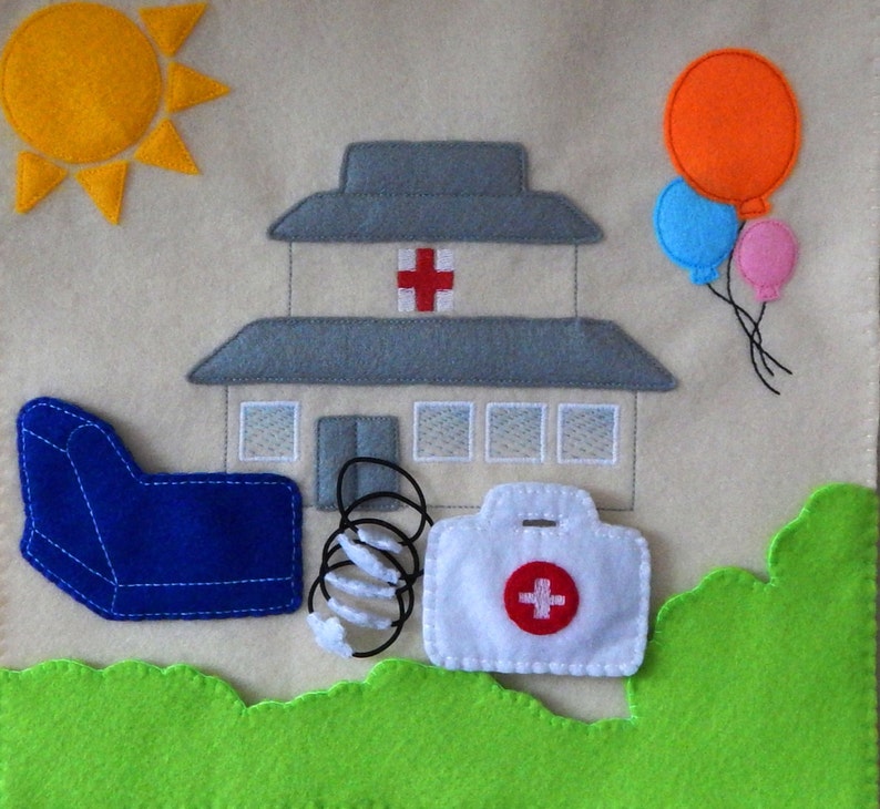 Puede incluir: Un conjunto de juego de fieltro con un sill&oacute;n azul, un resorte, un botiqu&iacute;n blanco con una cruz roja, un edificio gris con una cruz roja, un sol amarillo y tres globos en naranja, azul y rosa.