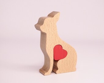 May include: Wooden toy dog figurine with a red heart cutout in its chest. The dog is sitting with its head tilted to the side.