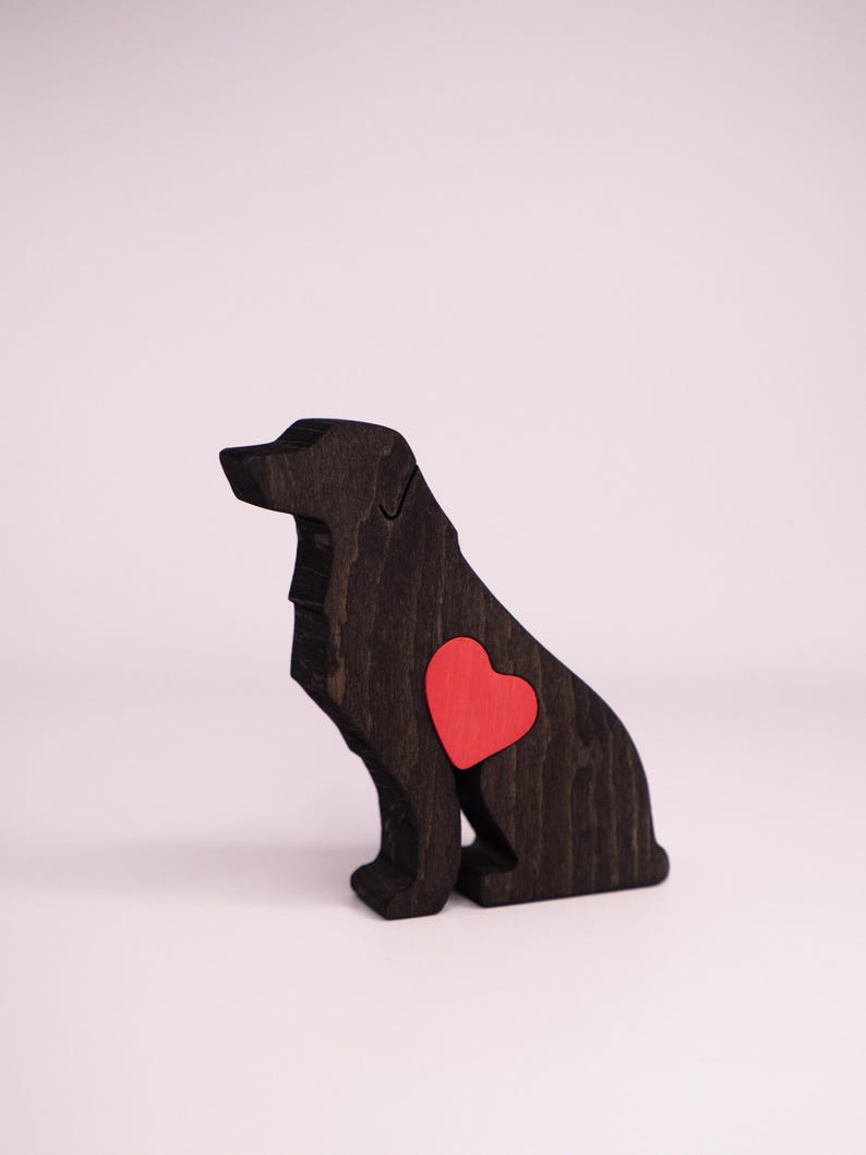 May include: A wooden dog figurine in a sitting position, stained dark brown. A bright red heart is inlaid on the dog's side. The figurine is a decorative item, likely for home decor or as a gift for dog lovers.