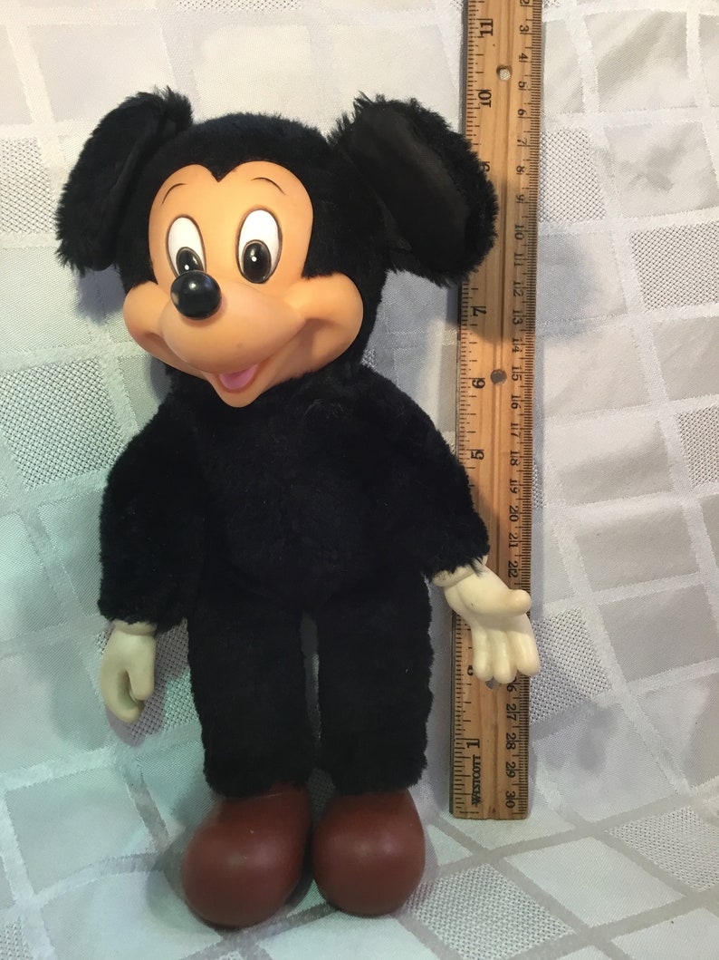 Puede incluir: Un mu&ntilde;eco de peluche vintage de Mickey Mouse. El mu&ntilde;eco tiene un cuerpo negro, orejas grandes negras y una cara bronceada con una expresi&oacute;n sonriente. Tiene zapatos rojos y mide aproximadamente 46 cm de alto.