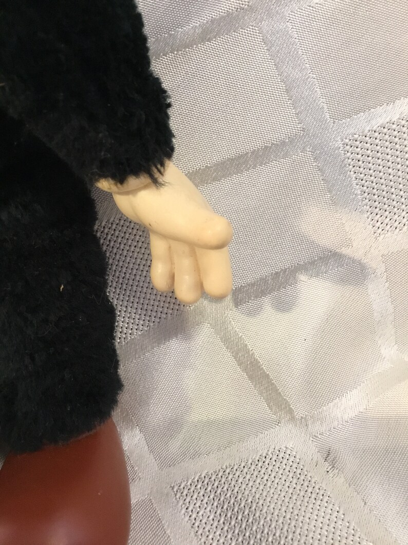 Puede incluir: Primer plano del brazo y la mano de una mu&ntilde;eca. El brazo de la mu&ntilde;eca est&aacute; cubierto de material negro y difuso, y la mano es de un tono de piel p&aacute;lido. El brazo de la mu&ntilde;eca est&aacute; doblado por el codo y la mano est&aacute; abierta.