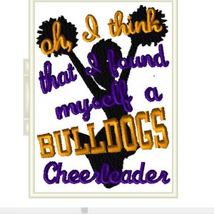 May include: A black silhouette of a cheerleader holding pom-poms with the text "Oh, I think that I found myself a BULLDOGS Cheerleader" in gold and purple lettering.