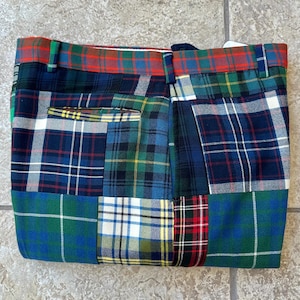 以下が含まれることがあります： 緑、青、赤、白など、さまざまな色のパッチワークチェック柄のパンツ。 パンツは、さまざまなチェック柄のパターンを組み合わせており、ウエストバンドとポケットが見えます。 生地は中程度の重さの素材のようです。