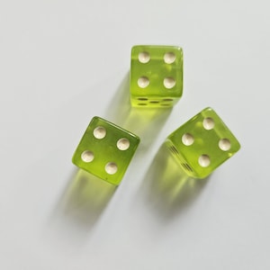 May include: Three translucent lime green six-sided dice with rounded corners. Each die features white circular pips representing the numbers. The dice are arranged in a triangular formation, showing various faces with different pip counts.