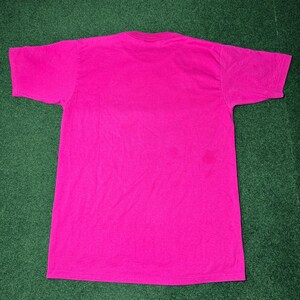 May include: A bright pink t-shirt with short sleeves.