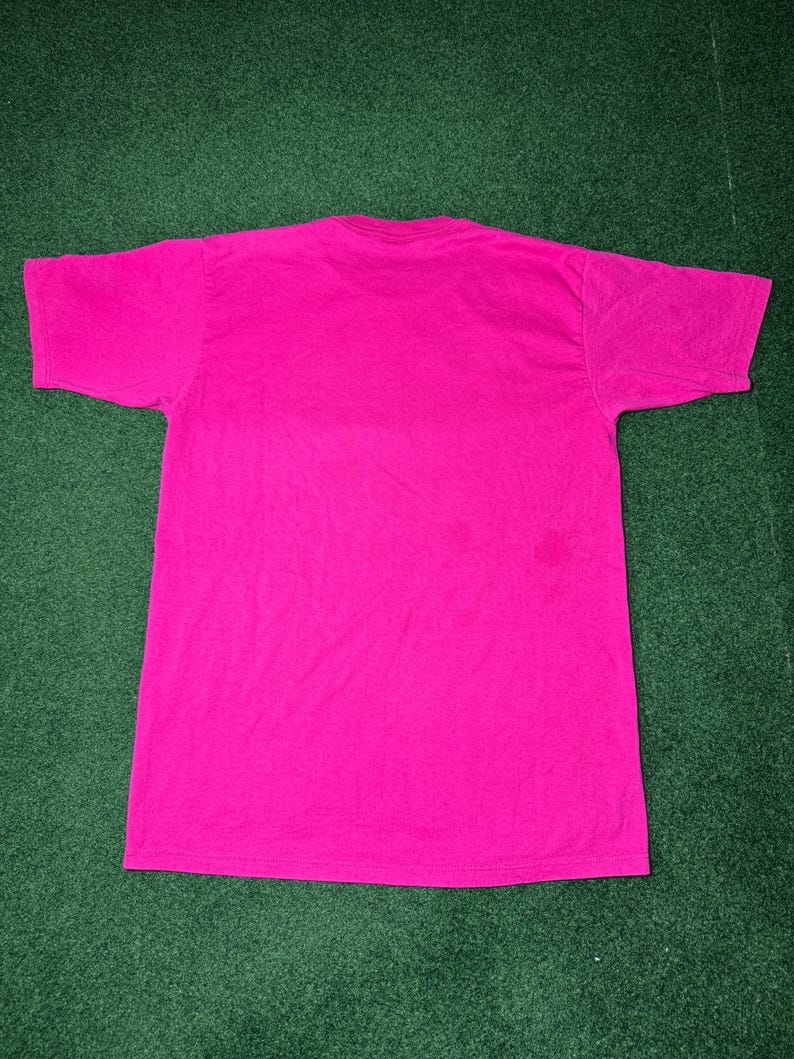 May include: A bright pink t-shirt with short sleeves.