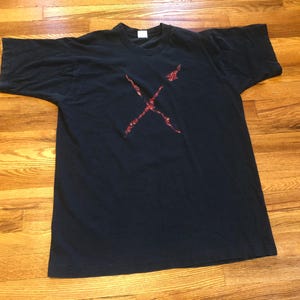 May include: A black t-shirt with a red graphic of two crossed swords.