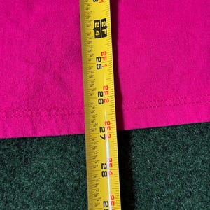 May include: A close-up of a yellow measuring tape with black markings. The tape is extended to 29 inches and shows markings for 1/8, 1/4, 1/2, and 3/4 inches.