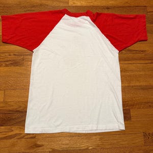 Pu&ograve; includere: Una maglietta bianca e rossa in stile baseball. La maglietta ha un corpo bianco e maniche rosse. La maglietta &egrave; realizzata in un materiale morbido e leggero.