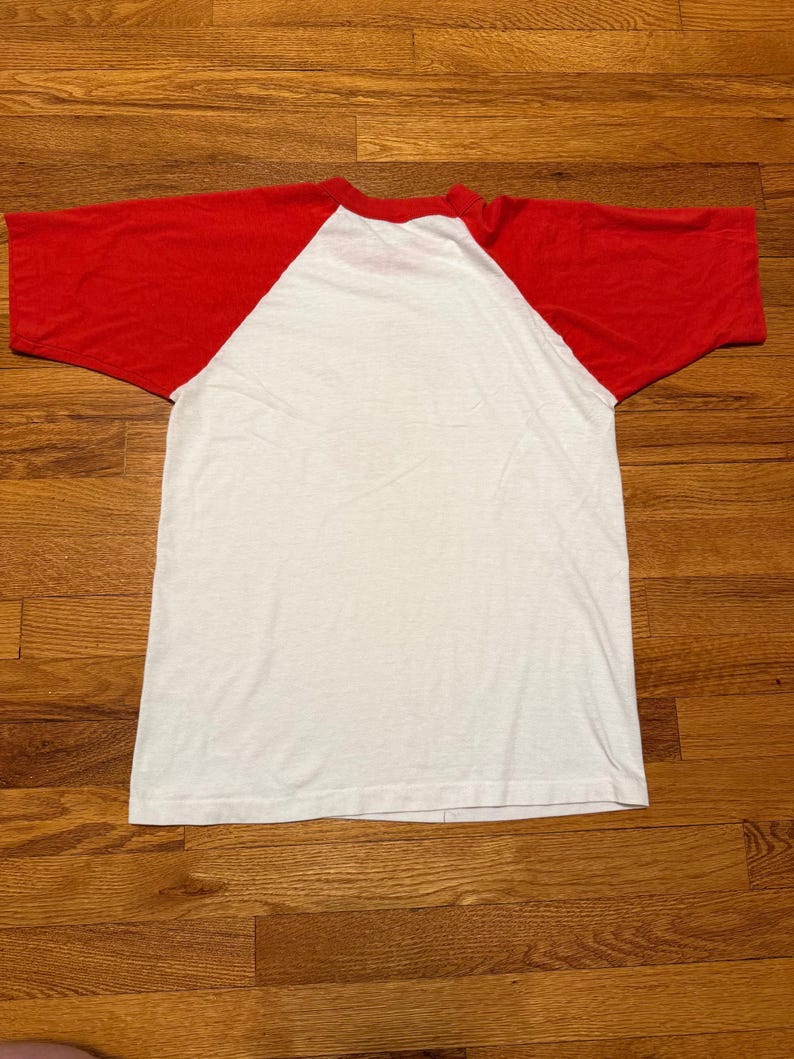 Pu&ograve; includere: Una maglietta bianca e rossa in stile baseball. La maglietta ha un corpo bianco e maniche rosse. La maglietta &egrave; realizzata in un materiale morbido e leggero.