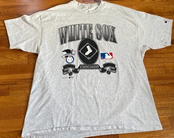 May include: A gray t-shirt with a vintage design featuring the words "White Sox" and a baseball logo. The shirt also includes the words "Chicago" and "Major League Baseball".