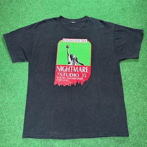 Puede incluir: Camiseta negra con un gráfico de una persona en un círculo verde y rojo. El texto en el gráfico dice "Nightmare at Studio 35".