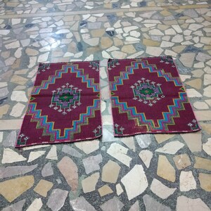 Puede incluir: Dos alfombras de oraci&oacute;n de color rojo, azul y verde con patrones sobre un suelo de baldosas.