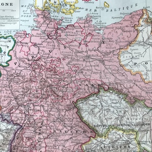 May include: A detailed vintage map of Germany, featuring a pink and white color scheme with text in French. The map shows the country's borders, cities, and geographical features. The word "ALLEMAGNE" is at the top.