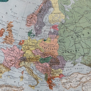 May include: A vintage map of Europe, featuring countries in various colors. The map includes labels in French and other languages, with detailed geographical features and country borders. The map is a historical representation of the continent.