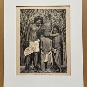 May include: An antique black and white print titled "Natives and Idol of the Marquesas." The image depicts three people standing near a carved idol. The print is framed in a white mat.