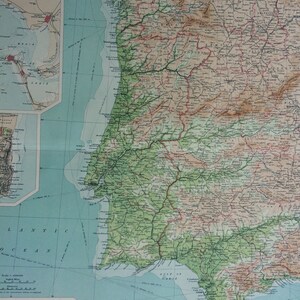 May include: A detailed vintage map of the Iberian Peninsula, showing Portugal and Spain. The map uses a palette of greens, browns, and blues to illustrate geographical features. It includes cities, rivers, and coastal areas, with inset maps and text labels.