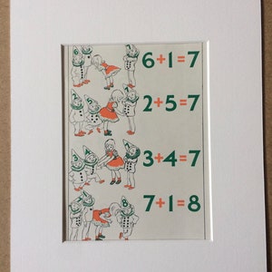 May include: A framed vintage print featuring whimsical illustrations of children and gnomes, with simple addition equations in green text. The print is matted in white, ready for display.
