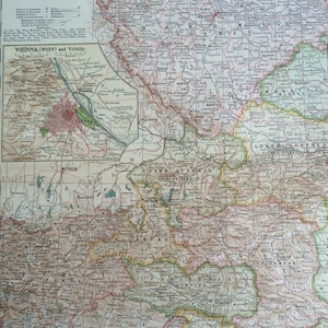May include: A detailed antique map of Austria-Hungary, Western Part, with insets of Vienna and its vicinity. The map features intricate details, including cities, rivers, and geographical features, with a color palette of muted greens, browns, and pinks. The text "VIENNA" is visible.