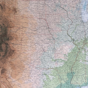 May include: A vintage map of the central United States, showing state borders, rivers, and cities. The map is printed on paper with a light brown background and features a color gradient to indicate elevation.
