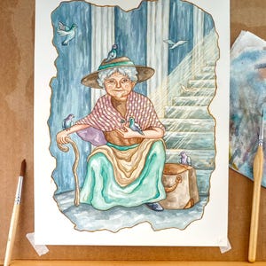 K&ouml;nnte beinhalten: Ein Aquarellbild einer &auml;lteren Frau, die auf einer Steintreppe mit einem Gehstock und einer braunen Tasche sitzt. Sie tr&auml;gt ein gr&uuml;nes Kleid, einen braunen Schal und einen Hut. Sie h&auml;lt einen Vogel in jeder Hand. Um sie herum fliegen andere V&ouml;gel.