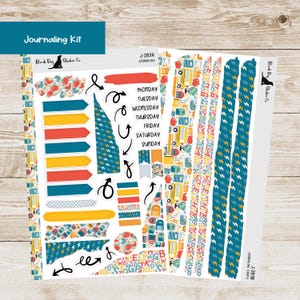 May include: A journaling kit with various stickers. The kit includes arrow-shaped stickers in red, yellow, and blue, along with decorative strips and labels for each day of the week. The kit also features a black dog logo and the text "Journaling Kit".