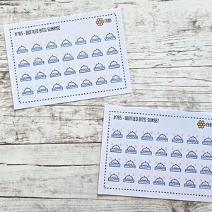 May include: Two rectangular sticker sheets featuring small sun and water icons. The top sheet is labeled #765 - BOTTLED BITS: SUNRISE with yellow suns. The bottom sheet is labeled #765 - BOTTLED BITS: SUNSET with pink suns. Both include a BHD logo.