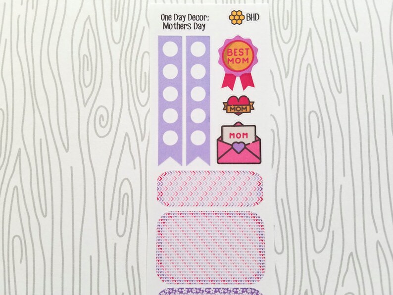 May include: A sheet of decorative stickers with a Mother's Day theme. The stickers include a "Best Mom" ribbon, heart-shaped accents, and an envelope with "Mom" on it. The color palette is primarily purple, pink, and red.