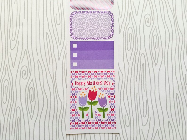 May include: A sheet of decorative stickers with a Mother's Day theme. The stickers feature floral and butterfly patterns in shades of pink, purple, and red. The text "Happy Mother's Day" is displayed on one of the stickers.