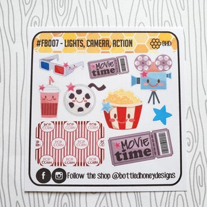 May include: A set of 10 movie-themed stickers featuring a popcorn bucket, a film reel, a 3D glasses, a movie ticket, a camera, and a star. The stickers are on a white background with a honeycomb pattern and the text "#FB007 - LIGHTS, CAMERA, ACTION" and "BHD".