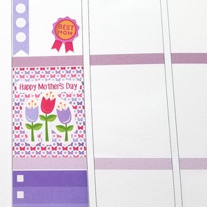 May include: A planner page with decorative stickers for Mother's Day. The stickers include a pink envelope with "MOM" text, a "BEST MOM" ribbon, and a floral design with the text "Happy Mother's Day".