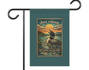 May include: A teal garden flag with a black metal stand. The flag features a vintage-style illustration of a loon on a lake with a sunset and the text "Just vibing and yelling into the void."