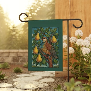 Könnte beinhalten: Eine grüne Gartenflagge mit einer detaillierten Illustration eines Vogels, der auf einem Ast mit gelben Birnen sitzt. Der Vogel hat braune, blaue und gelbe Federn. Der Hintergrund ist ein blauer Himmel.